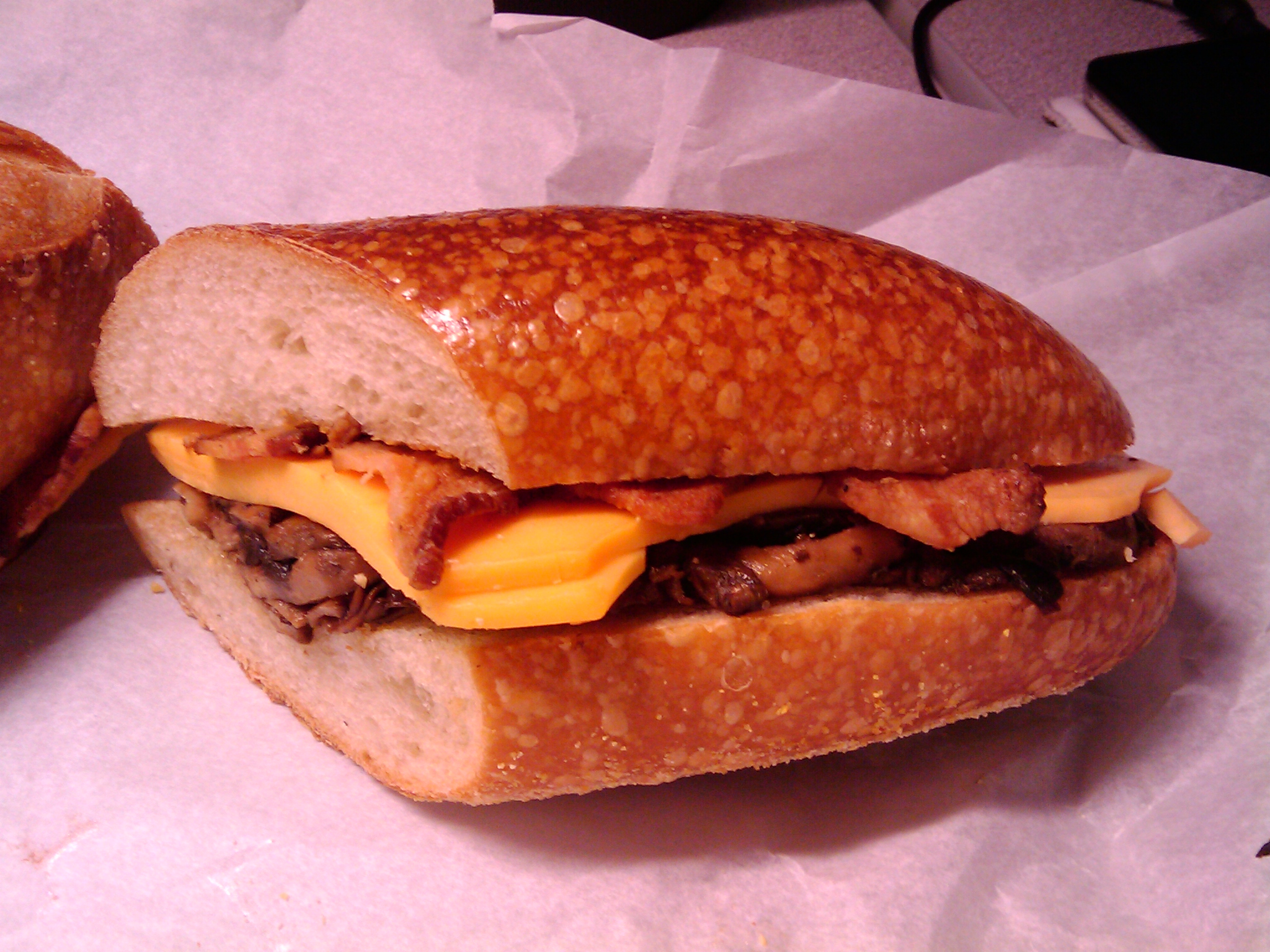 Today's lunch is a sandwich of sharp cheddar, dryly sauteed garlic mushrooms, and Edwards' Berkshire Bacon. 