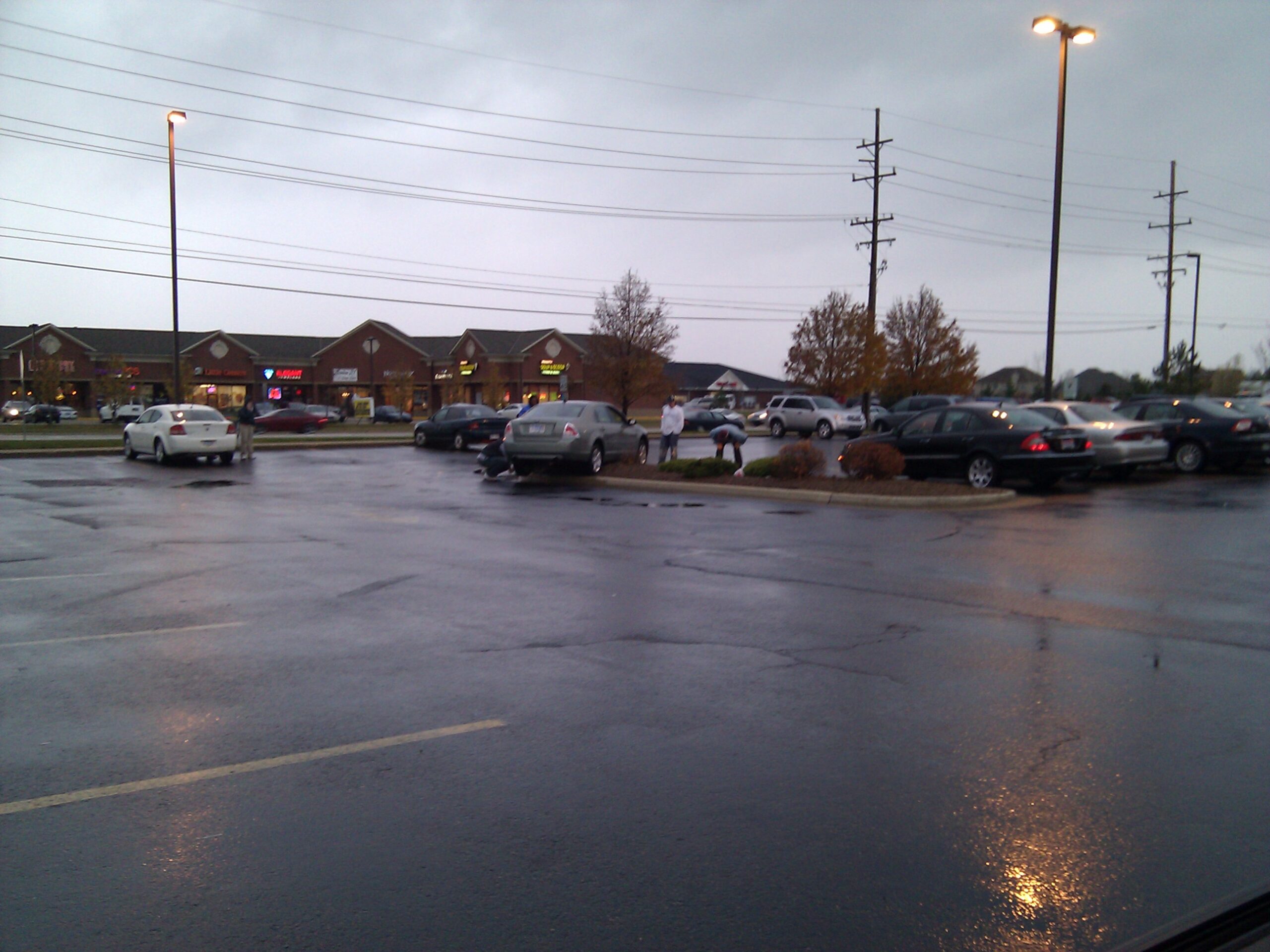 Vehicle with a handicapped plate centered on a grassy parking median. The car was stuck with the front (drive) wheels not making contact with the ground.
