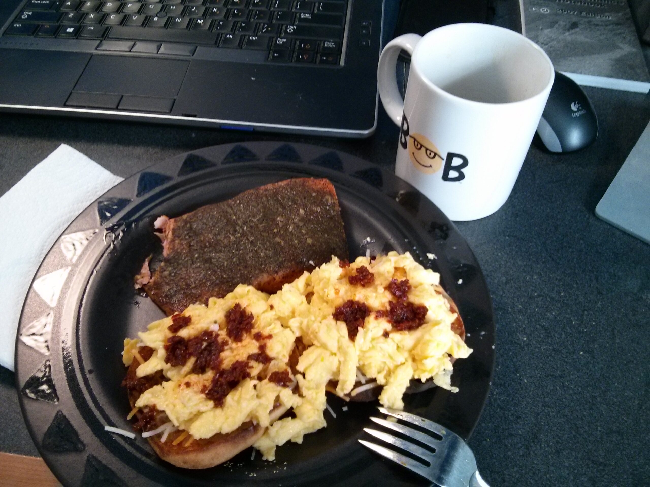 Herbed smoked salmon, an English muffin topped with scrambled egg, cheddar, and harissa, with a cup of coffee. This was a good lunch.