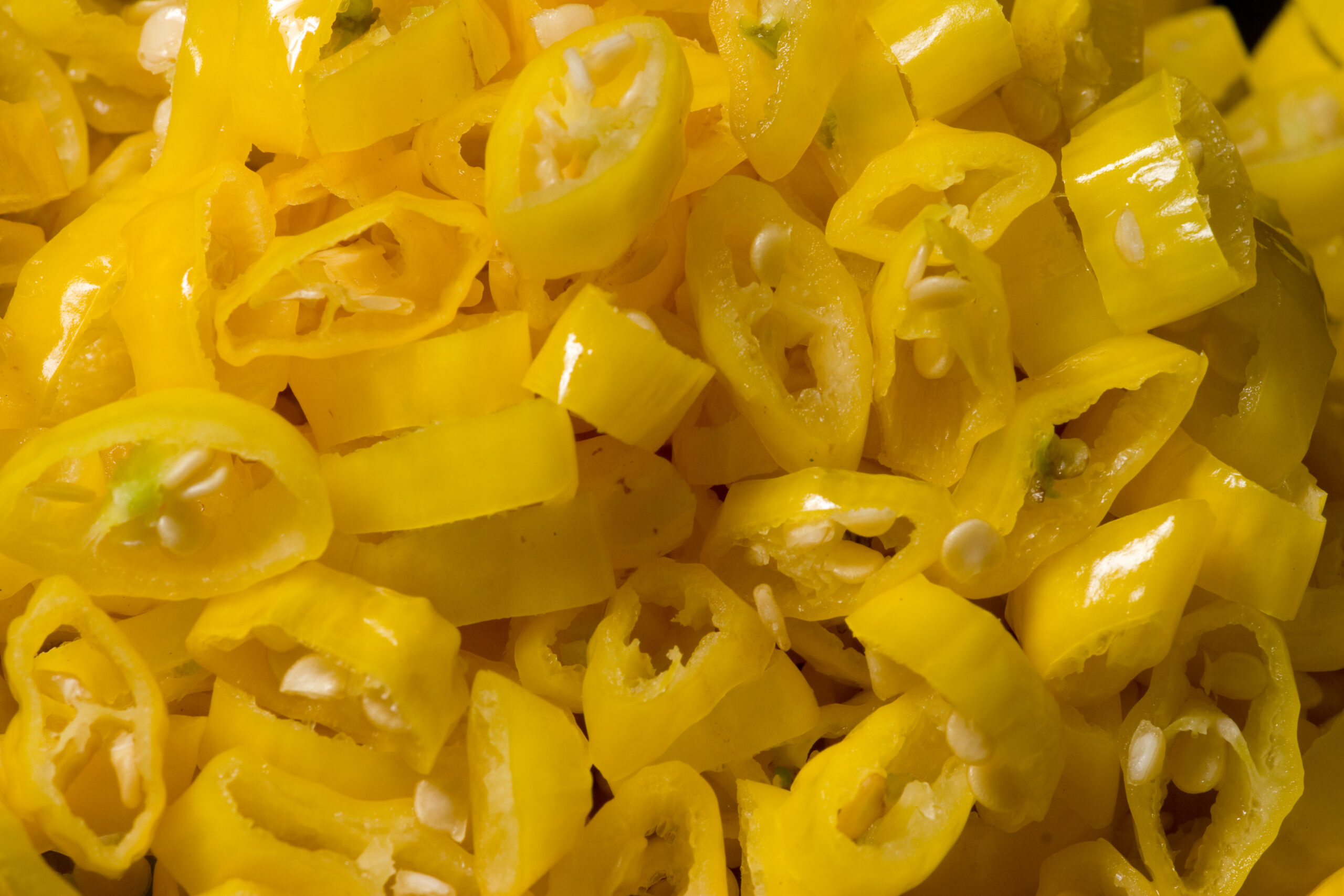 Lemon drop chile peppers, cut into slices, to be used in the preparation of a hot sauce.