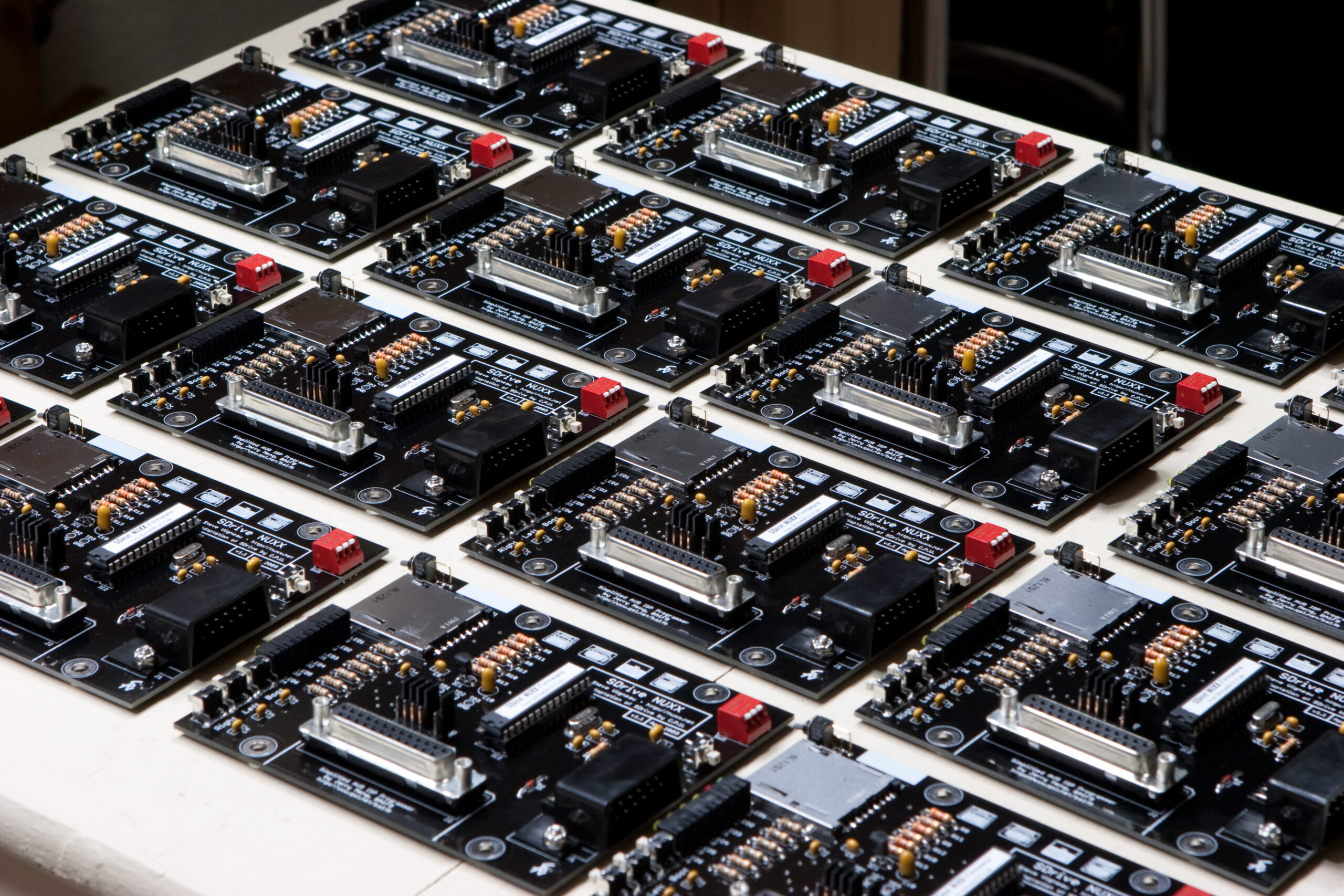 Sixteen of the assembled SDrive NUXX PCBs. They have all passed initial testing and are ready to be inserted into enclosures.