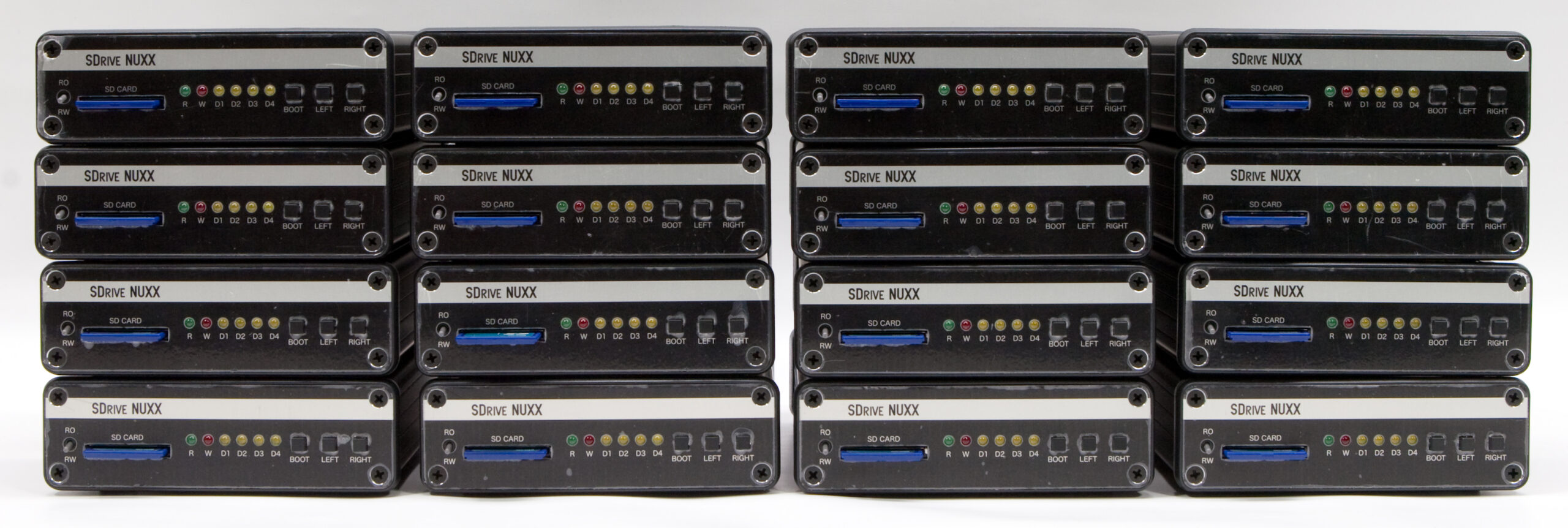 Sixteen assembled SDrive NUXXs, with 2GB Kingston SD cards, ready for final testing.