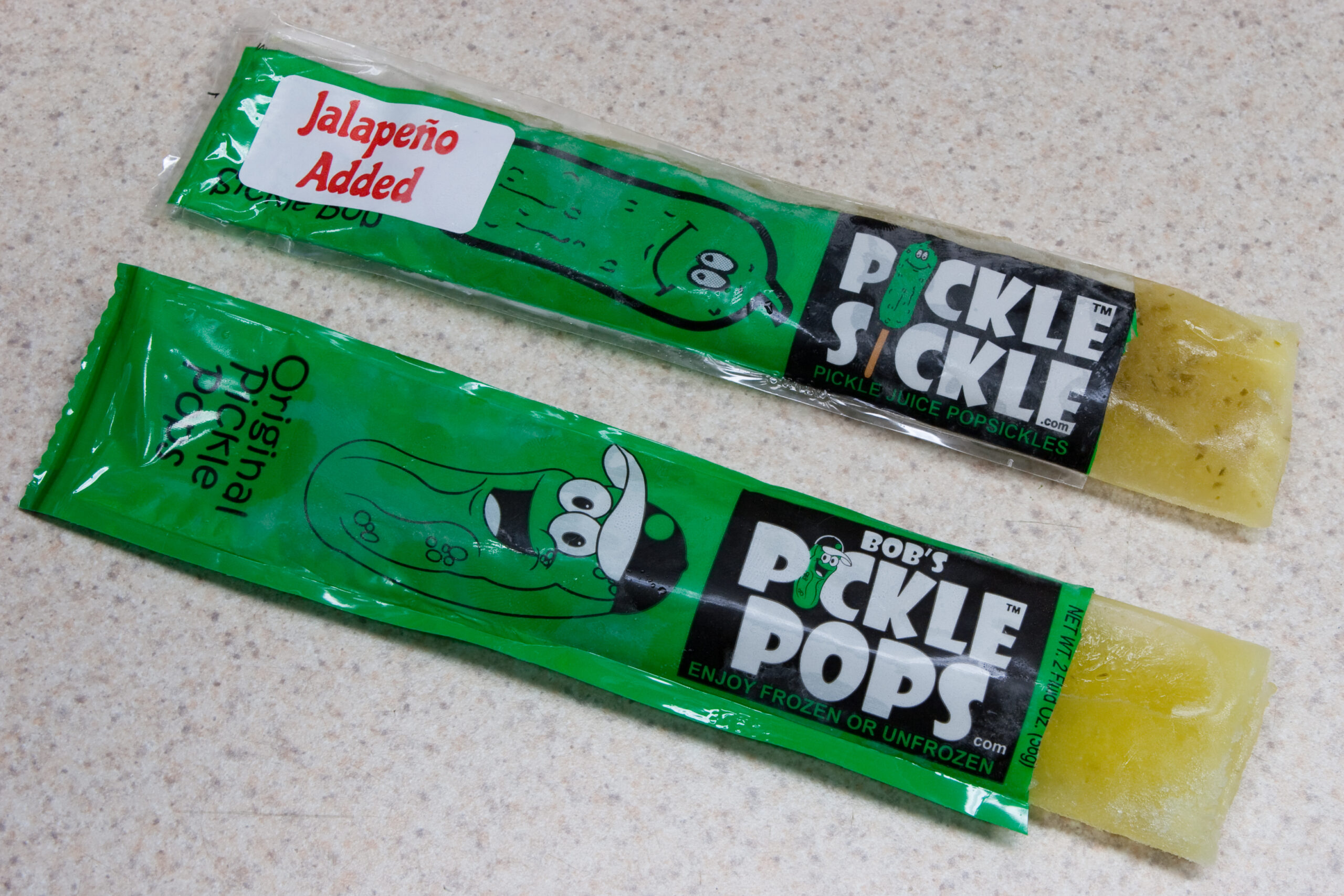 One each of Bob's Pickle Pops, regular and jalapeno flavor, opened. They taste very interesting and remind me of Mexican candy.