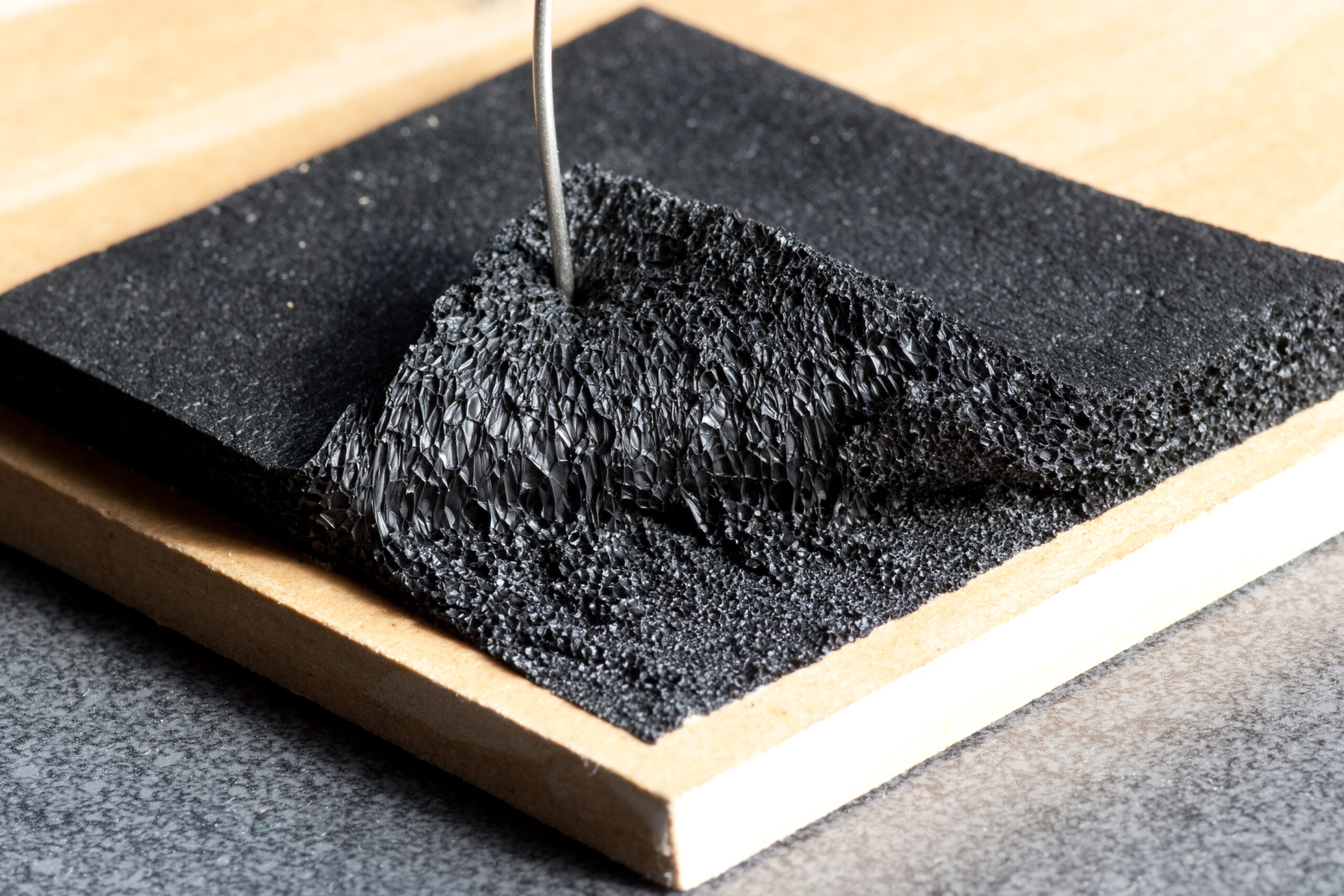 Test neoprene piece stuck to hardboard with standard DAP Weldwood Contact Cement.