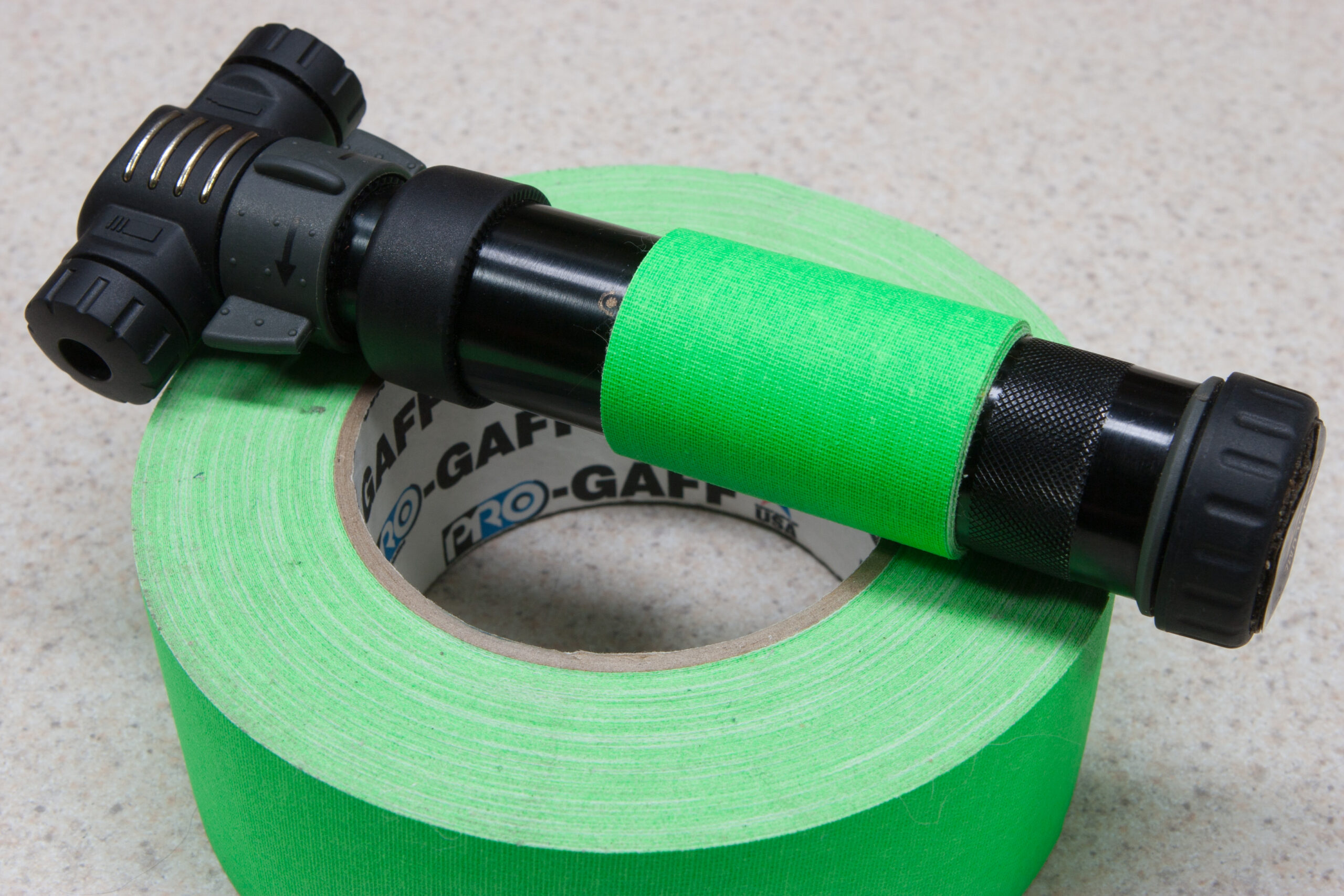 Seven or eight turns of fluorescent green Pro-Gaff gaffer's tape wrapped around the handle of a Crank Brothers Power Pump Ultra bicycle pump.