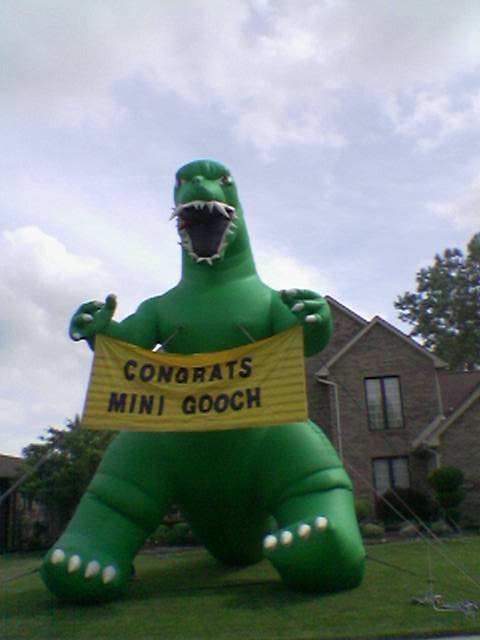A large inflatable monster holding a sign reading &quote;CONGRATS MINI GOOCH&quote;, seen outside of a house in Shelby Township one Saturday afternoon.