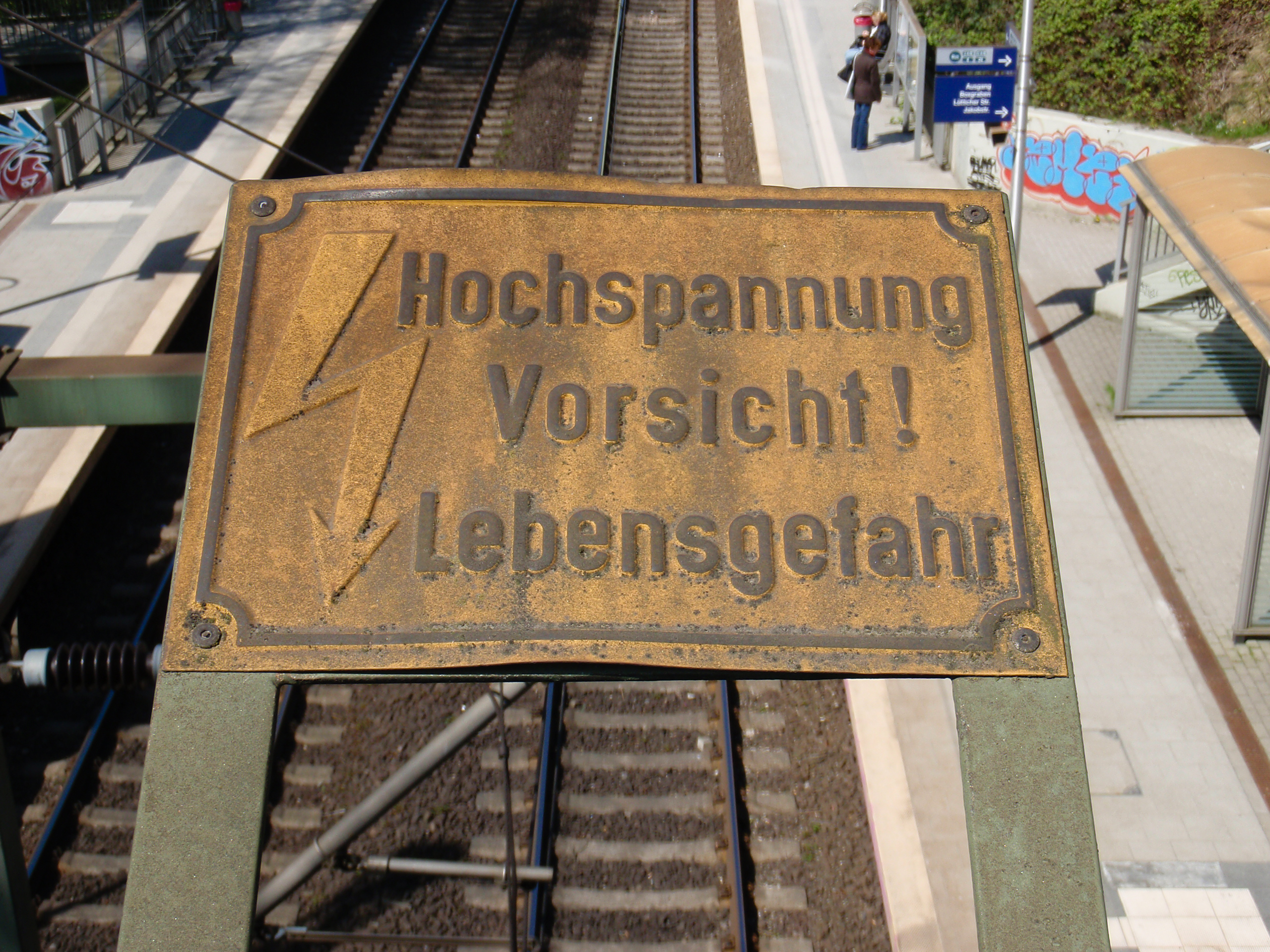"Hochspannung Vorsicht! Lebensgefahr" reads the sign, indicating that there are high voltage lines (and thus danger) below.