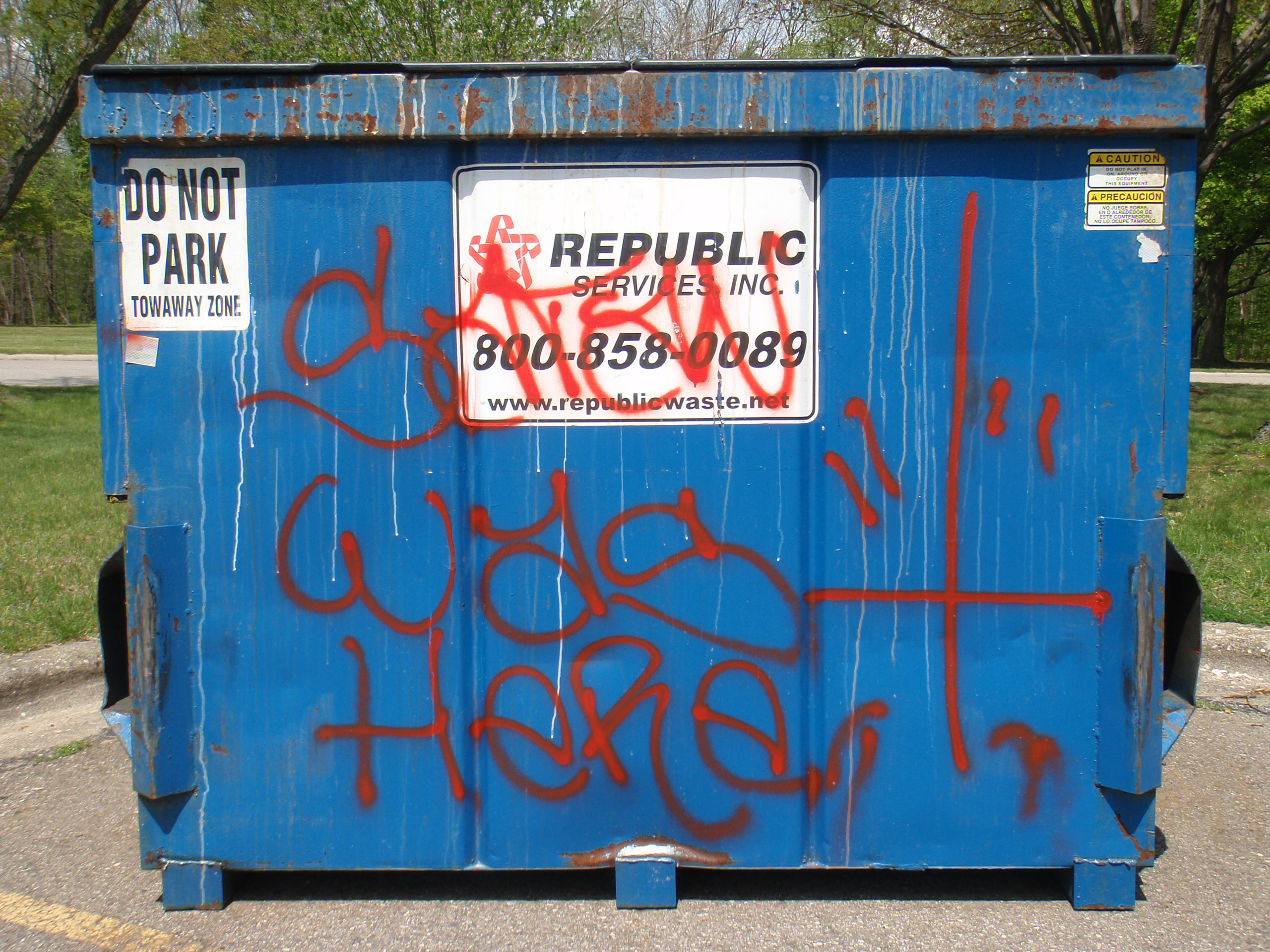 Satan Was Here graffiti, including a double-quoted upside down cross, seen in the parking lot at River Bends.